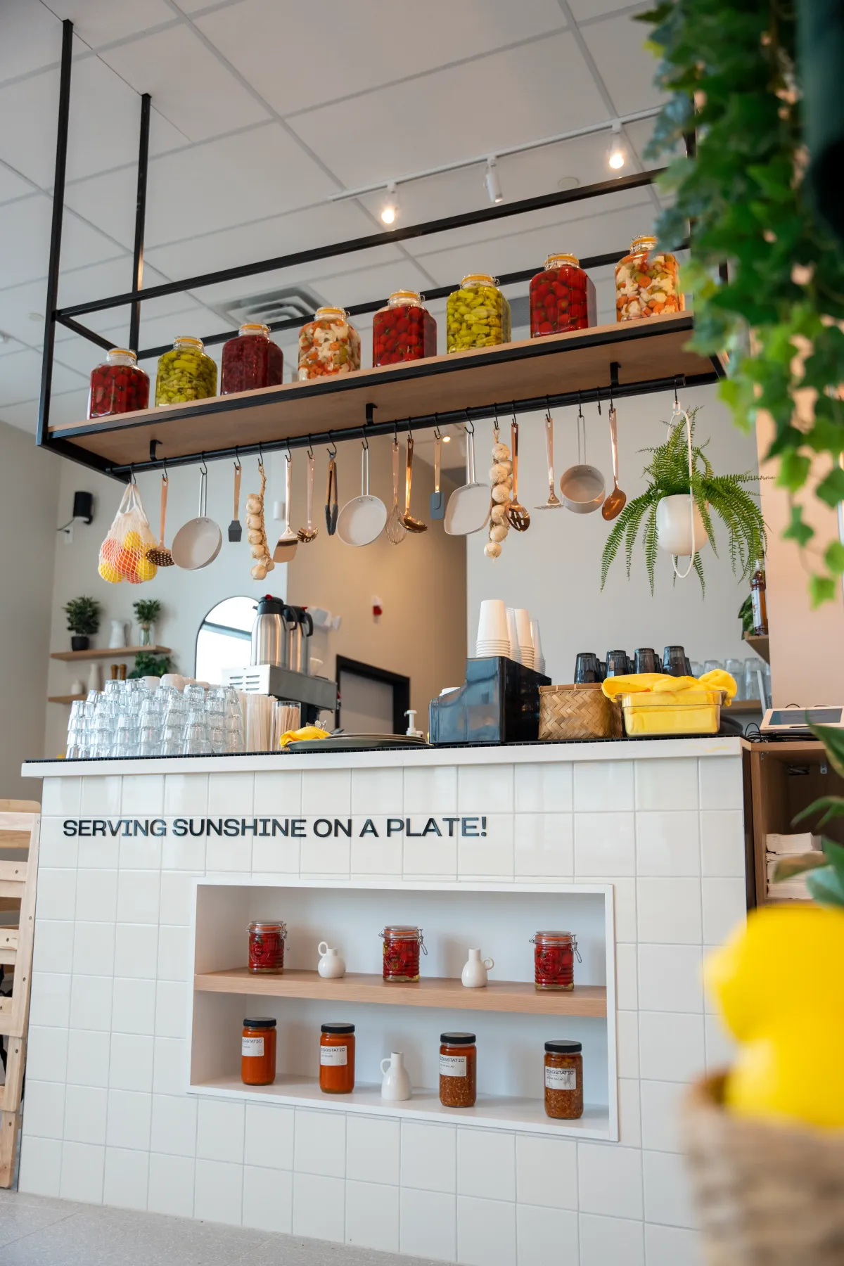 Eggstatic service counter with hanging utensils and shelves of preserve jars