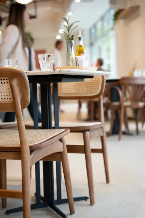 Sunlit dining area with cane-back chairs and marble two-tops at Eggstatic London Ontario