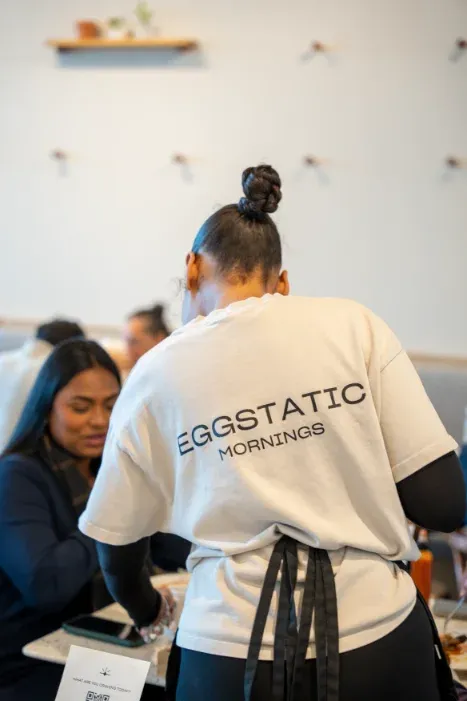 Server in Eggstatic Mornings tee taking a guest's order at Eggstatic Scarborough