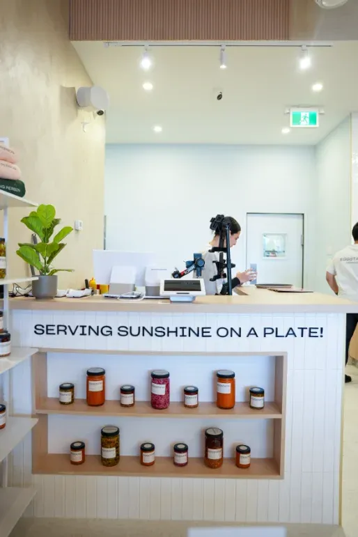 Pickup counter with "Serving Sunshine on a Plate" tagline and preserves at Eggstatic Waterdown