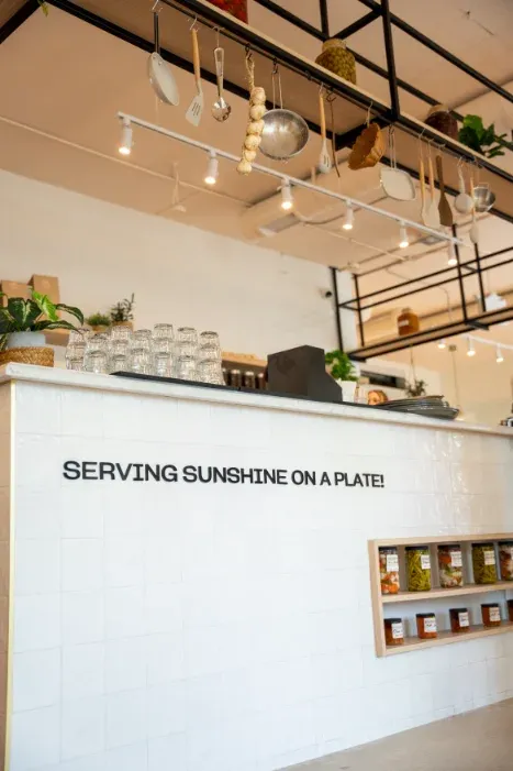 "Serving Sunshine on a Plate" service counter and hanging utensils at Eggstatic London Ontario