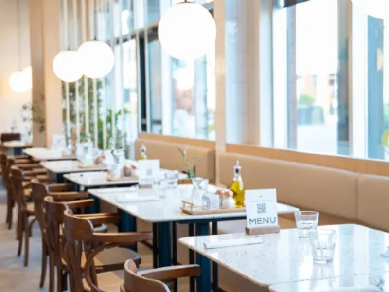 Sunlit row of marble tables and globe pendant lights at Eggstatic Oakville