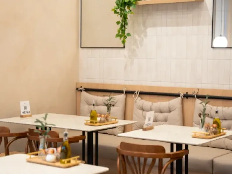 Two-top tables with banquette seating and arched mirrors at Eggstatic Oakville