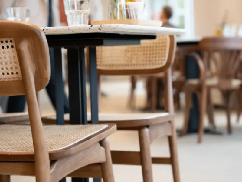 Sunlit dining area with cane-back chairs and marble two-tops at Eggstatic London Ontario