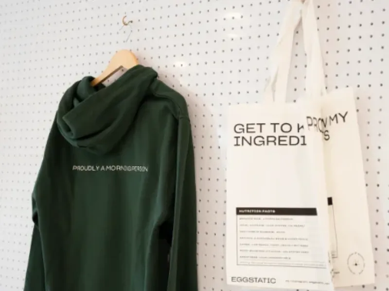 Green Eggstatic hoodie and "Get to know my ingredients" tote on the merch pegboard at Eggstatic London Ontario