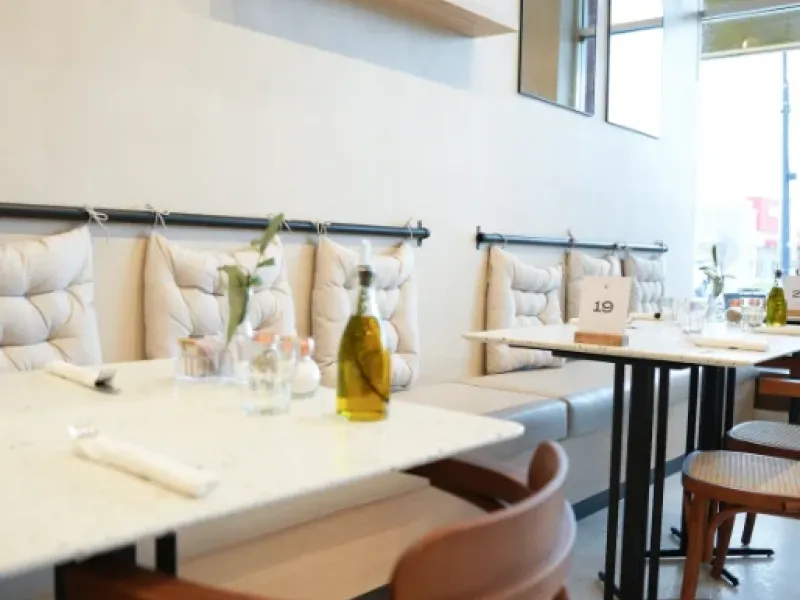 Banquette seating with marble tables and styling shelves at Eggstatic Waterdown